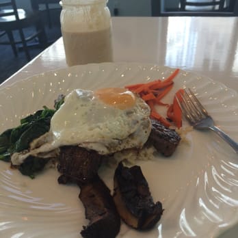 Fried egg over a seasonal vegetable hash with mushrooms and spinach